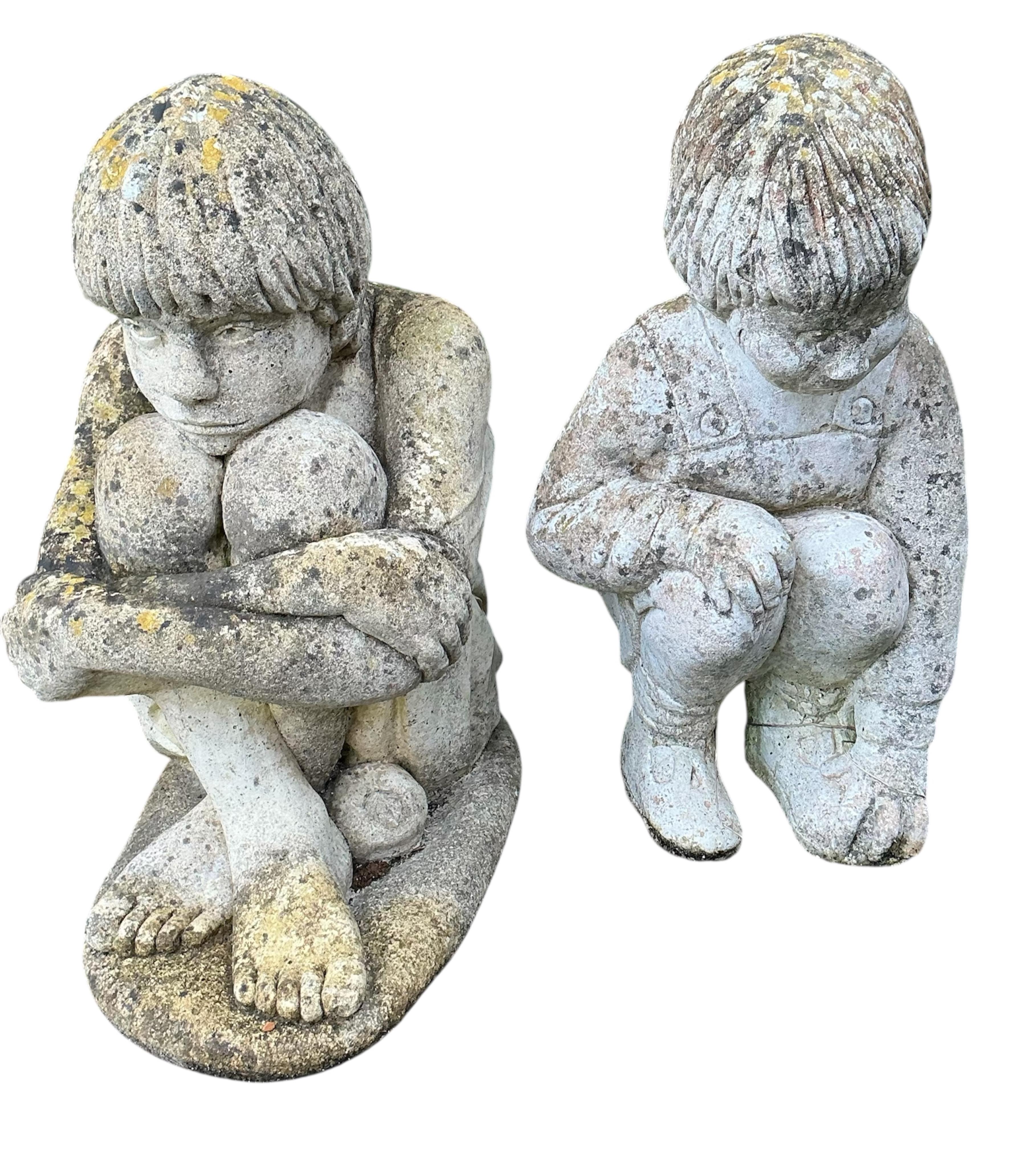 Two reconstituted stone seated child garden ornaments, larger height 56cm